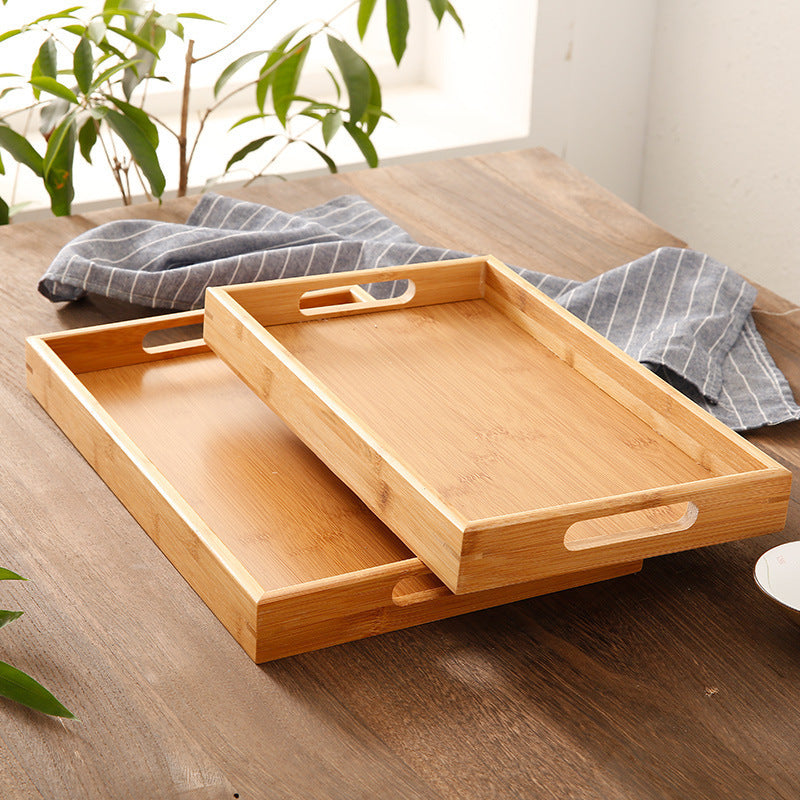 Bamboo Serving Trays stacked on each other, these trays are flat topped and have 2 handles each end.