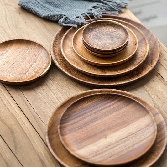Set of Walnut Wood Round Plates all stacked on top of each other, showing the beautiful wood and grain pattern.