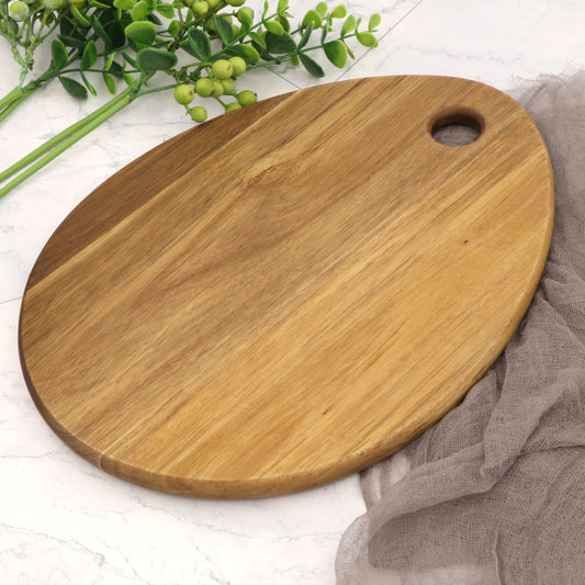 The Acacia Solid Tear Drop Cutting Board on a countertop.