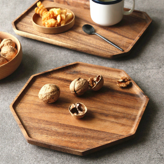 The Acacia Wood Plate holding 5 walnuts and you can see the wood grain on the plate below the nuts.