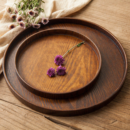 Ash Wood Round Serving Tray stacked on each other, with a purple flower on top of it.