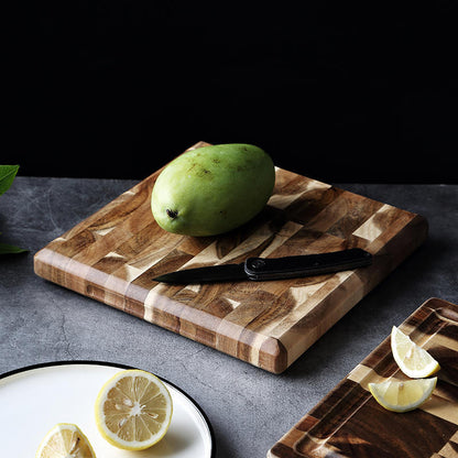 The small Parquet Acacia Wood Cutting Board with a green mango on it.