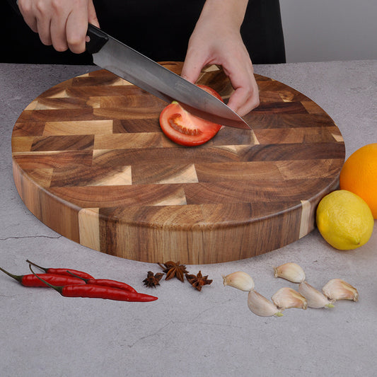 The Round End-Grain Acacia Board with tomatoes being cut on it.