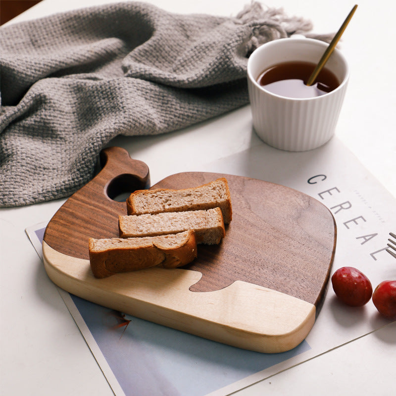 The small Black Walnut and Maple Whale Cutting Board with bread on it. Showing the beautiful wood grain and dark coloring.