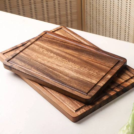 The small and large Acacia Thick One-Piece Wood Cutting Board stacked on top of each other.